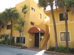 a yellow building with palm trees in front of it at Hollywood Sands Resort, a VRI resort in Hollywood