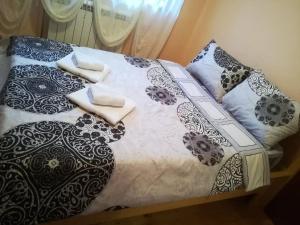 un letto con coperte e cuscini bianchi e neri di ***STEFANI Apartments a Kruševo