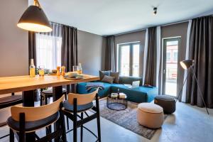 un soggiorno con tavolo e divano blu di EchtZeit - Dein Hotelquartier a Braunlage