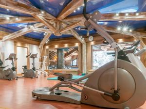 einen Fitnessraum mit mehreren Trainingsgeräten in einem Raum in der Unterkunft Residence Les Fermes de Meribel - maeva Home in Méribel