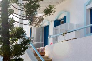 a stairway with blue doors and a palm tree at Ferma Hill Apartments in Ferma
