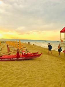 una playa con un barco rojo en la arena en B&B Il più bello, en San Salvo