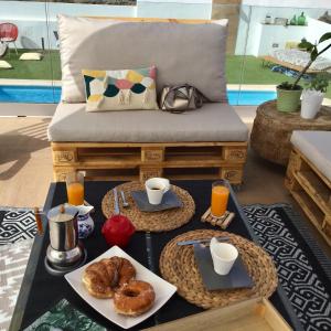 a coffee table with breakfast foods and drinks on a bench at El atardecer in Puerto del Rosario
