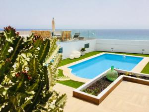 a swimming pool with the ocean in the background at El atardecer in Puerto del Rosario