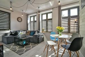 a living room with a couch and a table and chairs at Old Town LTC - Apartments Starówka Panieńska in Gdańsk