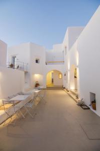 a large white room with chairs and tables in it at White Loft in Ios Chora