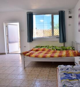 Schlafzimmer mit einem Bett und einem Fenster in der Unterkunft Victoriei 35B in Curtea de Argeş
