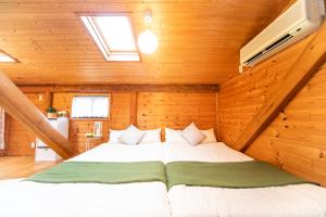 淡路市にあるAwaji Seaside Log Houseの木造キャビン内のベッド1台が備わるベッドルーム1室を利用します。