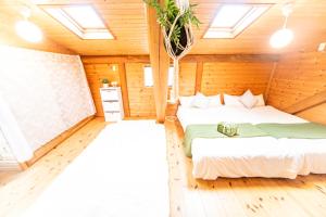 2 camas en una habitación con paredes de madera en Awaji Seaside Log House, en Awaji