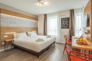 Cette chambre comprend un lit et une table avec un bol de fruits. dans l'établissement Residhotel Lyon Part Dieu, à Lyon