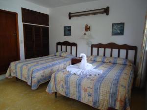 a room with two beds with a swan on them at Hotel Cozumel Costa Brava in Cozumel +25 photos