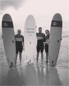 tres personas de pie en el agua sosteniendo sus tablas de surf en La villa tamaris maison à partager, en Vieux-Boucau-les-Bains