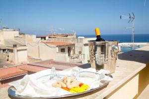 Un plato de comida en una repisa con una botella de vino. en Sicilia Case Vacanze, en Balestrate