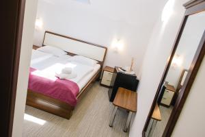 a small bedroom with a bed and a mirror at Villa Andor in Ankaran