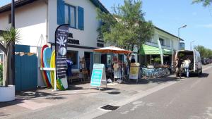 una tienda con tablas de surf al lado de una calle en La villa tamaris maison à partager, en Vieux-Boucau-les-Bains