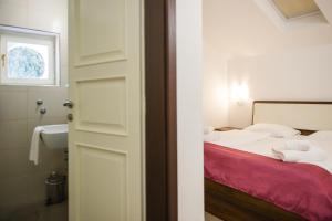 a bedroom with a bed and a bathroom with a sink at Villa Andor in Ankaran