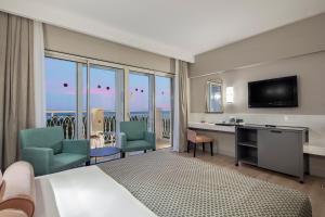 a hotel room with a bed and a desk and chairs at Trendy Aspendos Beach Hotel in Side