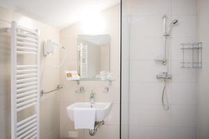 a white bathroom with a sink and a shower at Villa Andor in Ankaran