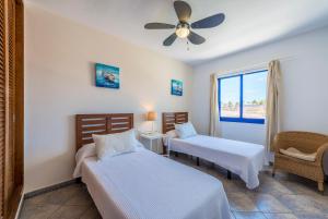 a bedroom with two beds and a ceiling fan at Villas Puerto Rubicon in Playa Blanca