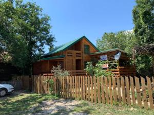 a wooden cabin behind a fence at Holiday Home Kite House in Ulcinj