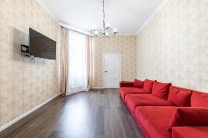 リヴィウにあるRelax apartmentのリビングルーム(赤いソファ、薄型テレビ付)