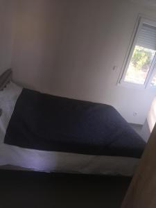 Bett in einem kleinen Zimmer mit Fenster in der Unterkunft T3 à Saint cyprien plage (400m de la plage) in Saint-Cyprien