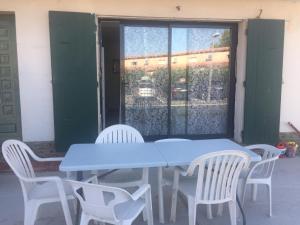 einem blauen Tisch und Stühlen vor einem Fenster in der Unterkunft T3 à Saint cyprien plage (400m de la plage) in Saint-Cyprien