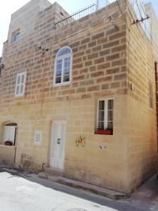 a yellow brick building with two windows and a white door at Sixty Two #4 in Victoria