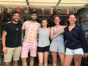 Eine Gruppe von Leuten, die sich für ein Foto in einem Fitnessstudio ausgeben. in der Unterkunft Hub of Joys Hostel in Ko Lanta