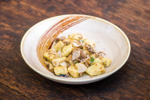 a white bowl of food on a wooden table at Villa Andor in Ankaran