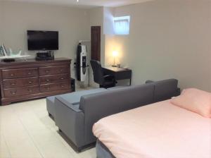 Un dormitorio con una cama, un televisor y un sofá. en myHome Basel, en Saint-Louis 5 fotos más