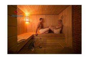un uomo e una donna seduti in una sauna di Mini spa Harmonija a Zapyškis