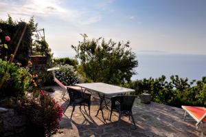 a patio with a table and chairs and the ocean at Casa Vigna Maria in Zanca