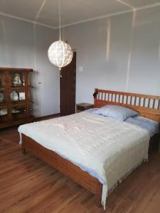 ein Schlafzimmer mit einem großen Bett und einem Kronleuchter in der Unterkunft Comfortable Apartment close to Spodek in Kattowitz