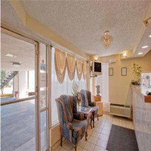 a living room with two chairs and a table at Americas Best Value Inn-Savannah in Savannah