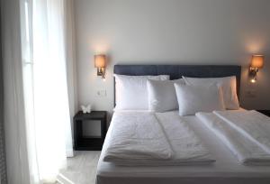 a bed with white sheets and pillows in a bedroom at Pansion Leggero in Krk