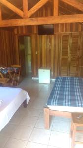 Zimmer mit einem Bett und einem Tisch in der Unterkunft Pousada Ypê das Montanhas in Monte Alegre do Sul