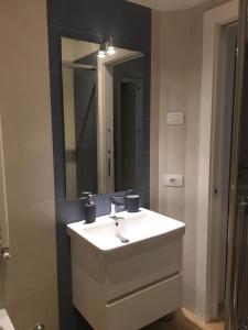 W łazience znajduje się biała umywalka i lustro. w obiekcie Appartamento Acquamarina w mieście San Benedetto del Tronto
