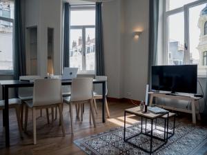 ブリュッセルにあるSmartflats - Fripiers Brusselsのリビングルーム(テーブル、椅子、テレビ付)