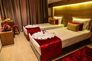 LE VOYAGEUR MARRAKECH في مراكش: غرفة فندق بسريرين ومخدات حمراء