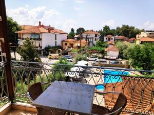 a table and chairs on a balcony with a view of a city at Pagaseon Rooms and Apartments in Kala Nera