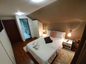 Schlafzimmer mit einem großen weißen Bett und einem Spiegel in der Unterkunft Casa Lucky in Râșnov