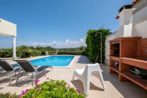 a patio with a swimming pool and chairs at Magnifica Moradia V4 in Casal da Lagoa Seca