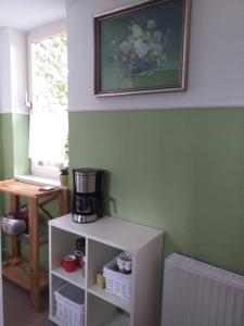 Zimmer mit Kaffeemaschine auf einem weißen Regal in der Unterkunft Bungalow am Donnerberg in Sewekow in Sewekow