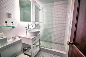 a white bathroom with a sink and a shower at The Exeter Inn in Exeter