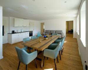 a dining room with a wooden table and blue chairs at Waldach Villa in Thalgau