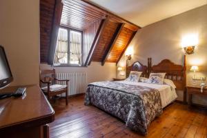 1 dormitorio con 1 cama, escritorio y ventanas en Hotel Fonfreda, en Vielha