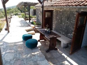 eine Terrasse mit einer Bank, einem Tisch und Stühlen in der Unterkunft Pirate's Nest Stone House in Korčula