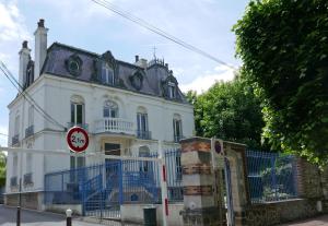 ein weißes Haus mit einem blauen Zaun davor in der Unterkunft VILLA CAMILLE - Proche Paris & Disneyland in Lagny