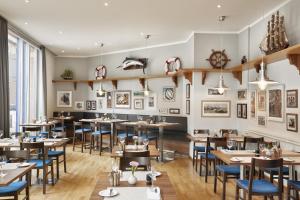 a restaurant with wooden tables and blue chairs at H4 Hotel Hamburg Bergedorf, Trademark Collection by Wyndham in Hamburg